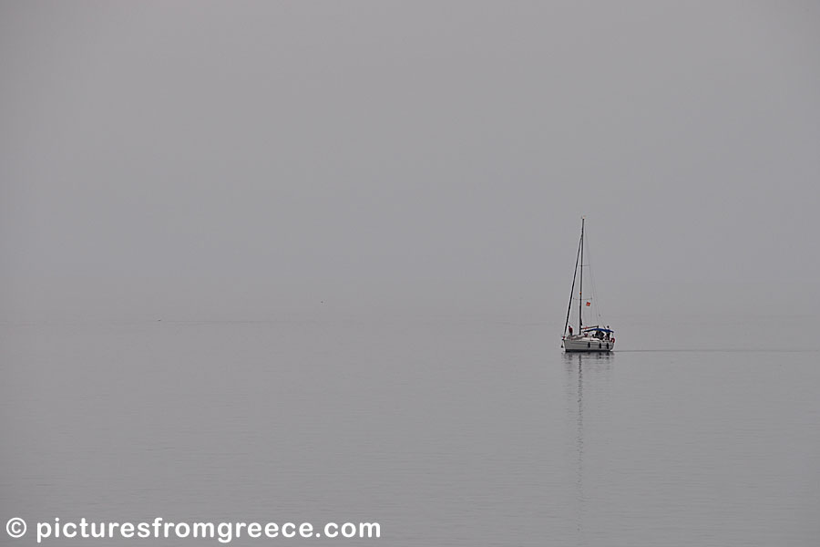 Fog and a sailboat in Skopelos Town .